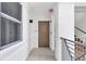 Well-lit hallway with neutral tones and convenient access to stairwell at 9203 Griggs Rd # A204, Englewood, FL 34224