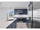 Well-lit kitchen with navy cabinets, stainless appliances, and a large island at 9203 Griggs Rd # A204, Englewood, FL 34224