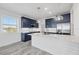 Modern kitchen featuring navy cabinets, stainless appliances, and a large island at 9203 Griggs Rd # A204, Englewood, FL 34224