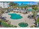 Beautiful community pool and hot tub area with lounge chairs and lush tropical landscaping at 9203 Griggs Rd # A204, Englewood, FL 34224