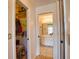 Bright bathroom with modern vanity, large mirror, and tiled flooring, next to an open closet at 9265 Carnation Ave, Englewood, FL 34224