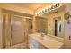 Bathroom features a walk-in shower and modern vanity with ample lighting and a large mirror at 9265 Carnation Ave, Englewood, FL 34224