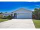 Charming single-story home with a well-manicured lawn and a spacious driveway leading to a two-car garage at 9265 Carnation Ave, Englewood, FL 34224