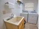 Functional laundry room with a utility sink and washer and dryer at 9265 Carnation Ave, Englewood, FL 34224