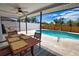 Covered patio area with dining table overlooking the pool and beautifully landscaped backyard at 9265 Carnation Ave, Englewood, FL 34224
