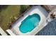 Aerial view of the sparkling pool with stairs inside fenced-in backyard at 9265 Carnation Ave, Englewood, FL 34224