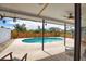 A covered patio looks out to a private pool surrounded by lush landscaping at 9265 Carnation Ave, Englewood, FL 34224