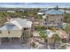 Expansive aerial view of a stilt home with a backyard pool, deck, and cabana, surrounded by lush tropical landscaping at 97 Kettle Harbor Dr, Placida, FL 33946