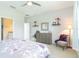 Bright bedroom with soft carpet, a ceiling fan, and view into ensuite bath and closet at 9936 Sheltering Spruce St, Englewood, FL 34223