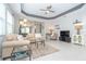 Comfortable living room with tile flooring, ceiling fan, and a partial view of the kitchen at 9936 Sheltering Spruce St, Englewood, FL 34223