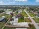 Aerial view of the property showcasing the layout, including the house, detached garage, pool, and surrounding neighborhood at 10075 Bay Ave, Englewood, FL 34224