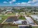 Aerial view of the expansive property with a pool enclosure, detached garage, and spacious yard, showcasing the home's location at 10075 Bay Ave, Englewood, FL 34224