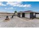 Gravel backyard with a fire pit, chairs, and a detached garage with white door; completely fenced for privacy at 10075 Bay Ave, Englewood, FL 34224