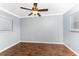 Bedroom featuring neutral walls, two windows, a fan, and wood-look flooring at 10075 Bay Ave, Englewood, FL 34224