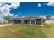 Charming home with a well-manicured lawn and nicely landscaped front yard at 10075 Bay Ave, Englewood, FL 34224