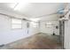 A look inside the garage, showing open storage space, three windows, and an unfinished floor at 10075 Bay Ave, Englewood, FL 34224
