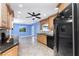 Open kitchen and breakfast nook with dark appliances, granite counters and wooden cabinets at 10075 Bay Ave, Englewood, FL 34224