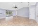 Bright living room with tile floors, ceiling fan, and sliding glass doors leading to an enclosed lanai and pool at 10075 Bay Ave, Englewood, FL 34224