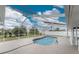 A screened-in pool with a handrail that leads into the water at 10075 Bay Ave, Englewood, FL 34224