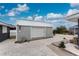 Exterior view of a durable shed with a roll-up door, ideal for storage or workshop space at 10075 Bay Ave, Englewood, FL 34224