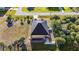 Aerial view showing backyard with screened-in pool, lush lawn, mature trees, and well-maintained surroundings at 10498 Bay State Dr, Port Charlotte, FL 33981