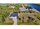 Aerial view showcasing a charming light-colored home with a spacious driveway, lush lawn and canal views at 10498 Bay State Dr, Port Charlotte, FL 33981