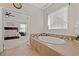 Bright bathroom featuring soaking tub and view into the main bedroom at 10498 Bay State Dr, Port Charlotte, FL 33981