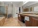 Well-lit bathroom with tile floors, double sinks, soaking tub, and glass enclosed shower at 10498 Bay State Dr, Port Charlotte, FL 33981
