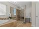 Elegant bathroom featuring tile floors, glass enclosed shower, and soaking tub at 10498 Bay State Dr, Port Charlotte, FL 33981