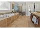 Bathroom featuring tile floors, soaking tub, glass enclosed shower, and double vanity at 10498 Bay State Dr, Port Charlotte, FL 33981