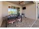 Covered outdoor patio featuring a dining table, ceiling fan, and mounted TV, perfect for entertaining at 10498 Bay State Dr, Port Charlotte, FL 33981
