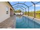 A luxurious screened in pool featuring beautiful neutral toned brick pavers surrounding the pool at 10498 Bay State Dr, Port Charlotte, FL 33981