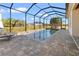 Screened-in pool with a brick paver deck and a relaxing outdoor space. Palm trees and blue skies enhance the view at 10498 Bay State Dr, Port Charlotte, FL 33981