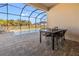 A view of the pool and outdoor dining area through the screen enclosure with view of neighboring houses at 10498 Bay State Dr, Port Charlotte, FL 33981