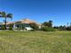 Expansive backyard with lush green grass and mature tropical landscaping at 108 Fairway Rd, Rotonda West, FL 33947