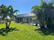 Expansive screened-in lanai with a pool and lush tropical landscaping with palm trees at 108 Fairway Rd, Rotonda West, FL 33947