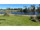 A serene backyard view showcasing a tranquil pond, vibrant green lawn, and an array of lush greenery at 108 Fairway Rd, Rotonda West, FL 33947