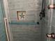 Stylish blue tiled shower showcasing modern fixtures, a built-in niche, and sleek glass door at 108 Fairway Rd, Rotonda West, FL 33947