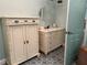 Elegant bathroom with custom white cabinets, complemented by a marble countertop and patterned tile flooring at 108 Fairway Rd, Rotonda West, FL 33947