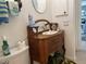 Quaint bathroom features vintage wooden vanity, decorative fixtures, and view into adjacent room at 108 Fairway Rd, Rotonda West, FL 33947