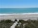 Beautiful view of a white sand beach, clear turquoise water, and lush natural greenery at 108 Fairway Rd, Rotonda West, FL 33947