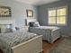 Coastal themed bedroom with two twin beds, seahorse patterned bedding and shuttered windows at 108 Fairway Rd, Rotonda West, FL 33947