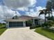 Charming single-story home with a two-car garage, a well-manicured lawn, and lush tropical landscaping at 108 Fairway Rd, Rotonda West, FL 33947