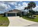 Charming single-story home with tropical landscaping, large driveway, and attached two-car garage at 108 Fairway Rd, Rotonda West, FL 33947