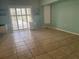 Bright living room with neutral tile flooring, plantation shutters, and light green walls at 108 Fairway Rd, Rotonda West, FL 33947