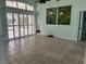 Spacious living room with tile flooring, shuttered sliding glass doors, and artwork on the pastel blue walls at 108 Fairway Rd, Rotonda West, FL 33947
