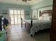 Comfortable main bedroom with bright walls, tile flooring, a large window, and stylish plantation shutters at 108 Fairway Rd, Rotonda West, FL 33947