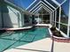 Sparkling pool within a screened enclosure, featuring a waterfall feature and ample deck space for relaxation and entertaining at 108 Fairway Rd, Rotonda West, FL 33947
