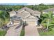 Aerial view of home with tile roof, three-car garage, paver driveway and manicured landscaping at 11417 Okaloosa Dr, Venice, FL 34293