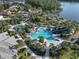 Aerial view of a stunning community pool with multiple pools, shaded seating, and a thrilling water slide at 11417 Okaloosa Dr, Venice, FL 34293
